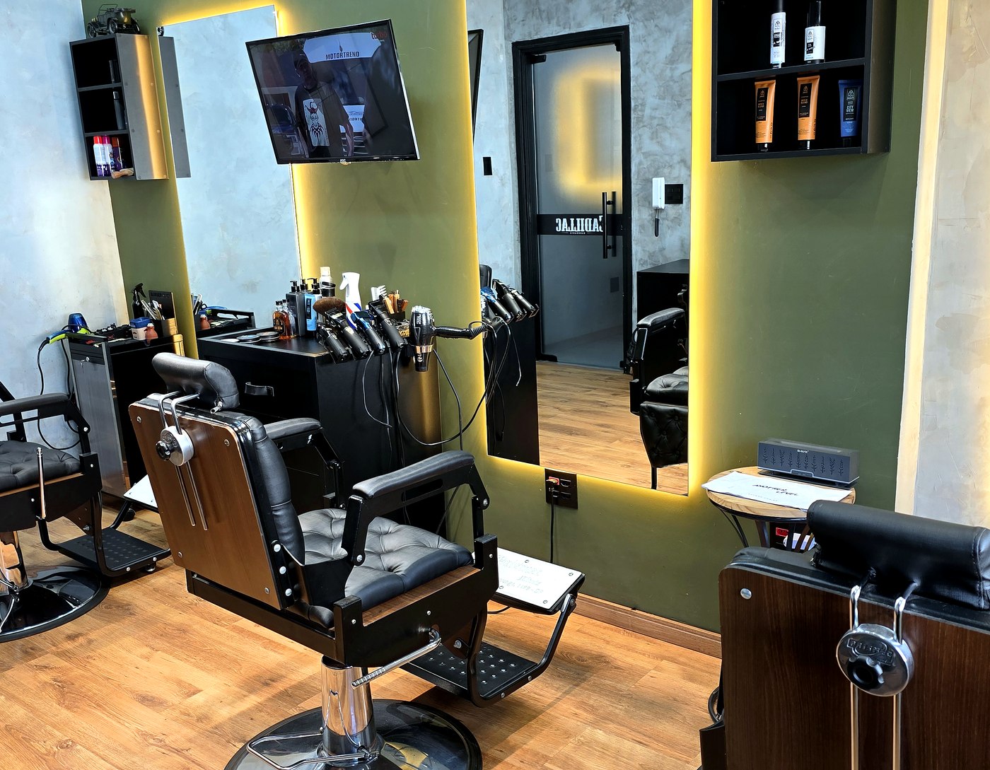 Estações principais da Barbearia Cadillac com cadeiras, espelhos iluminados e produtos organizados