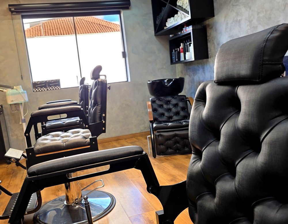 Sala reservada da Barbearia Cadillac com cadeira reclinável, lavatório e parede em cimento queimado